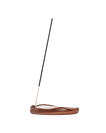 A single incense stick stands upright in a curved, polished brown wooden holder on a plain white background.