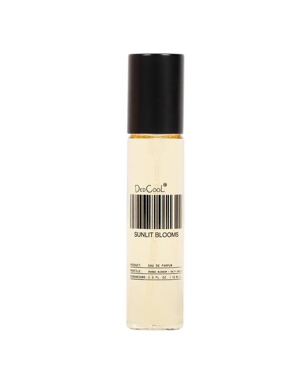 A clear cylindrical rollerball bottle with a black cap, containing a pale yellow liquid. The label reads 'DeeCool' and 'SUNLIT BLOOMS' with a barcode graphic, set against a plain white background.