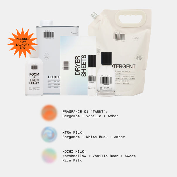 A set of laundry care products arranged on a light gray background: a large cream detergent bag, a white canister, a white box, a white dryer sheet packet, a small white bottle, and a clear bottle with a black cap. An orange burst says it includes a new laundry bag.